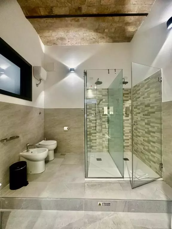 Bagno moderno di Domus Pretoria con ampia doccia, lavabo e kit di cortesia